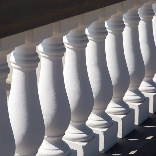 white baluster stone balusters closeup of an architectural structure lit by sunlight.